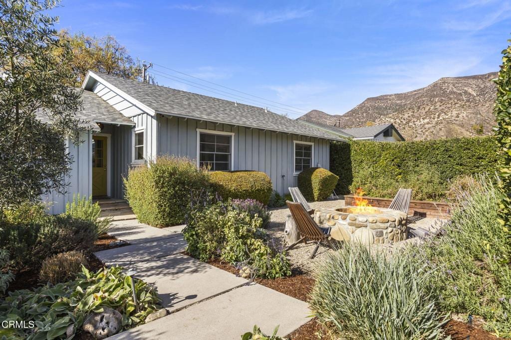 exterior space with a patio area, a fire pit, and a mountain view