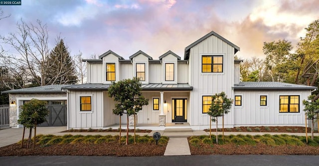 modern farmhouse style home with a porch and a garage