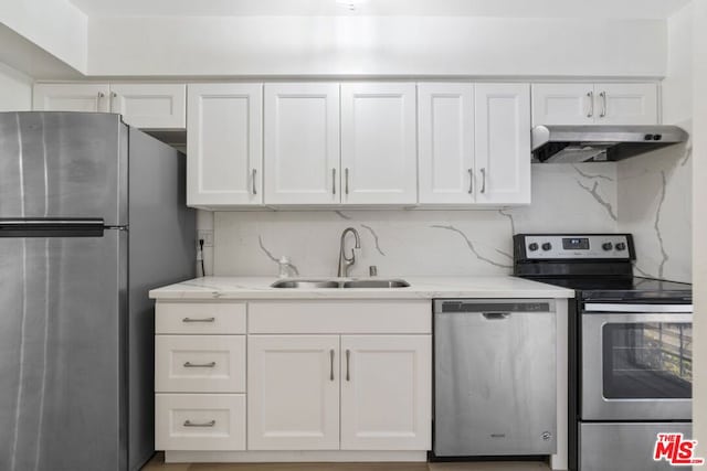 kitchen featuring decorative backsplash, sink, white cabinets, and stainless steel appliances