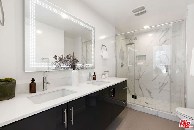 bathroom with vanity, toilet, and a shower with door