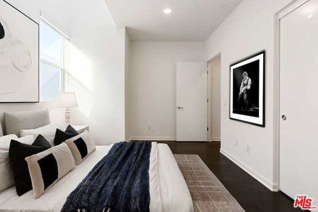 bedroom with dark hardwood / wood-style floors