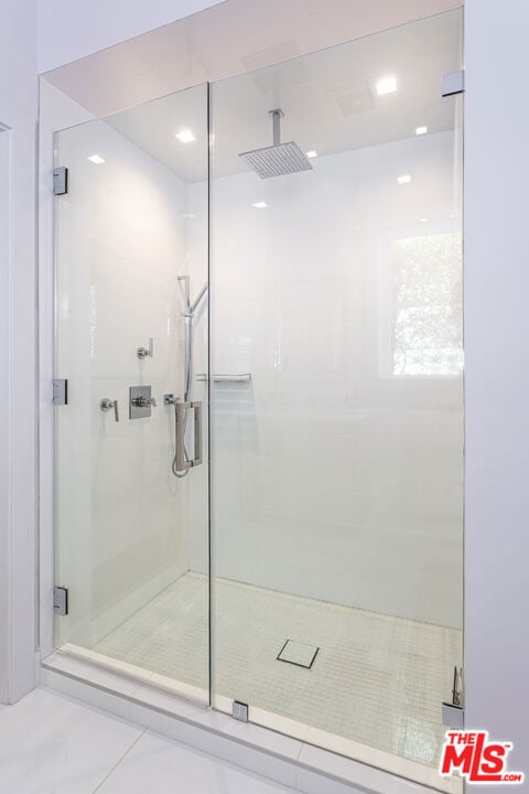 bathroom with tile patterned floors and a shower with shower door