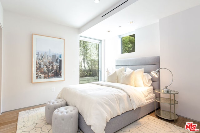 bedroom featuring light hardwood / wood-style flooring and a wall of windows