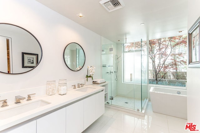 bathroom featuring shower with separate bathtub, vanity, and tile patterned floors