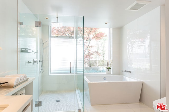 bathroom featuring plus walk in shower, tile patterned flooring, and vanity