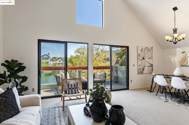 carpeted living room with an inviting chandelier, high vaulted ceiling, plenty of natural light, and a water view