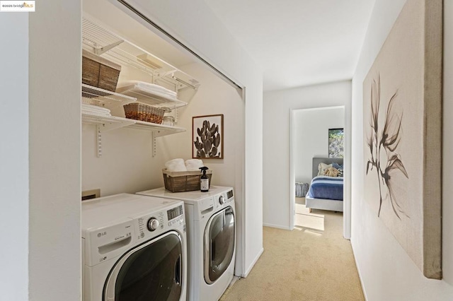 clothes washing area with independent washer and dryer and light carpet