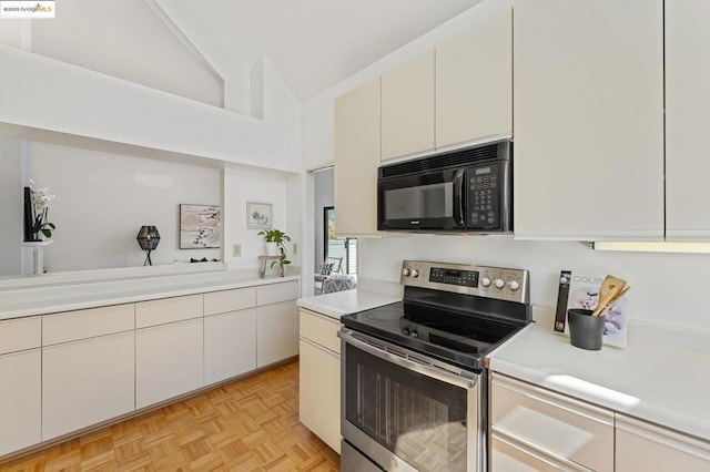 kitchen featuring vaulted ceiling, stainless steel electric range oven, white cabinetry, and light parquet floors