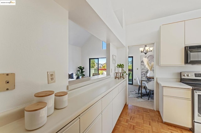 kitchen with electric range oven, light parquet flooring, a notable chandelier, vaulted ceiling, and white cabinets