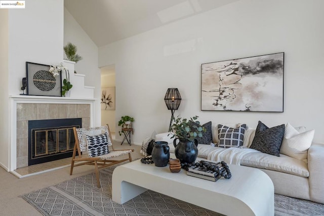 carpeted living room featuring a tile fireplace and high vaulted ceiling