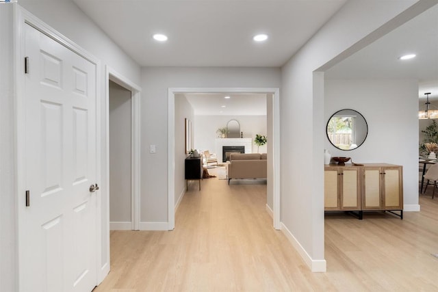 hall featuring light hardwood / wood-style floors and a chandelier