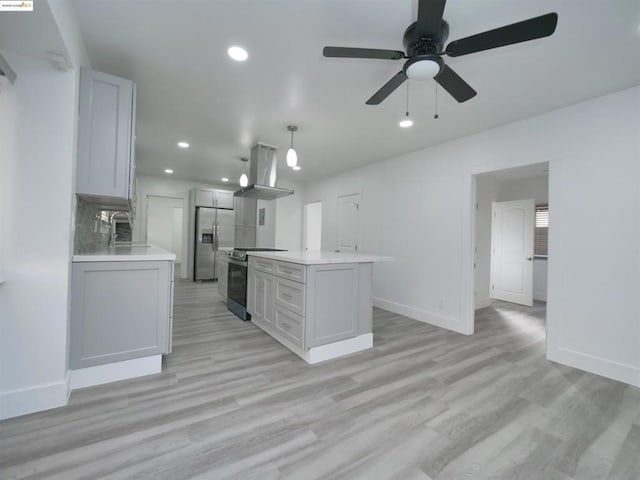 kitchen featuring ceiling fan, stainless steel appliances, decorative light fixtures, island range hood, and a kitchen island