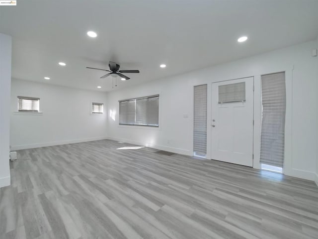 unfurnished living room with ceiling fan and light wood-type flooring