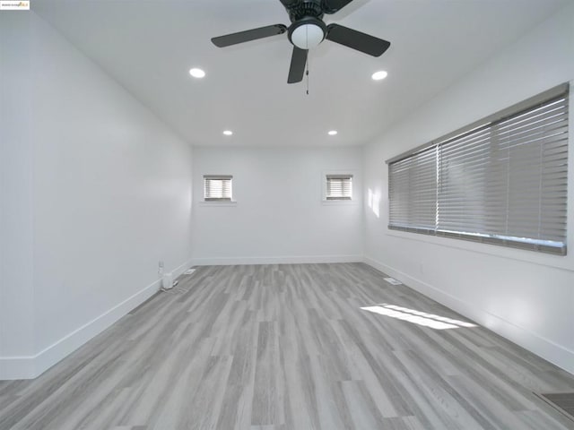 empty room with ceiling fan and light hardwood / wood-style flooring