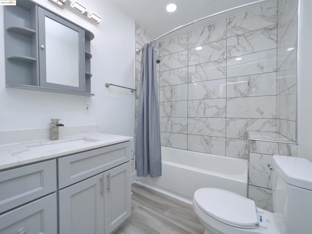 full bathroom featuring vanity, hardwood / wood-style flooring, toilet, and shower / bathtub combination with curtain