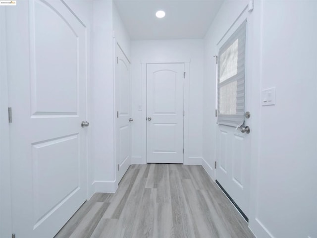 corridor with light hardwood / wood-style flooring