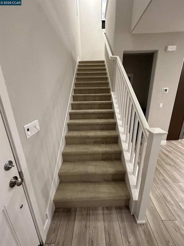 staircase with hardwood / wood-style floors