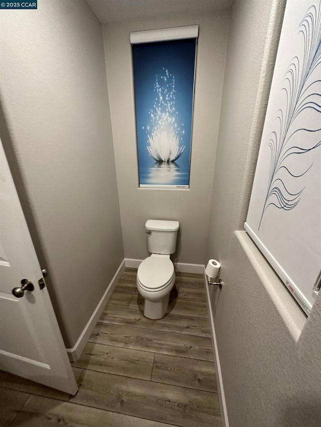 bathroom featuring hardwood / wood-style floors and toilet