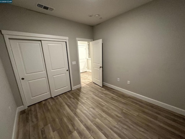 unfurnished bedroom featuring dark hardwood / wood-style flooring and a closet