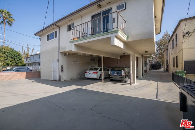 exterior space with a balcony and a carport