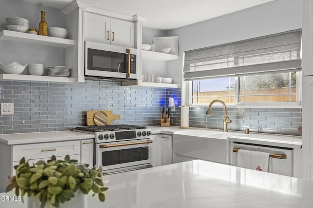 kitchen featuring backsplash, dishwasher, sink, white cabinetry, and stainless steel gas range