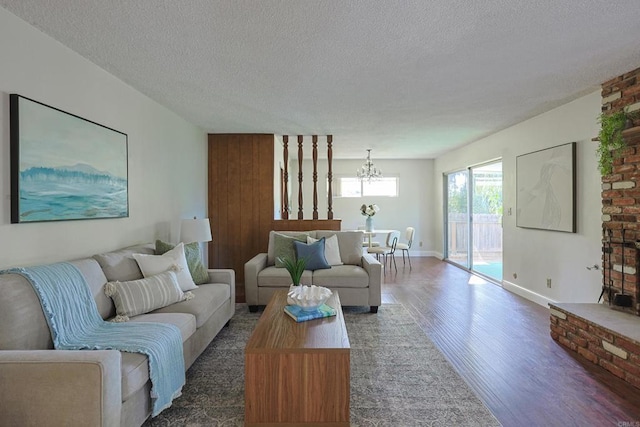 living room with dark hardwood / wood-style flooring, a textured ceiling, and a chandelier