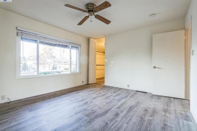 unfurnished bedroom with light wood-type flooring, ceiling fan, and a closet