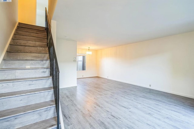 staircase featuring a chandelier and hardwood / wood-style floors