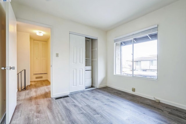 unfurnished bedroom with a closet and light hardwood / wood-style flooring