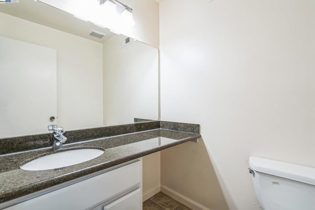 bathroom with toilet, tile patterned flooring, and vanity