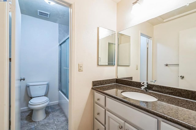 full bathroom featuring toilet, vanity, and combined bath / shower with glass door