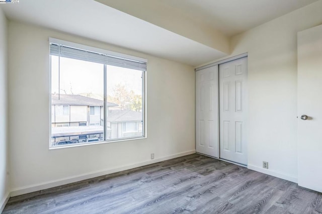 unfurnished bedroom with light hardwood / wood-style floors and a closet