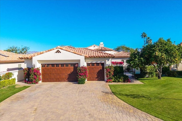 mediterranean / spanish-style house featuring a front yard and a garage