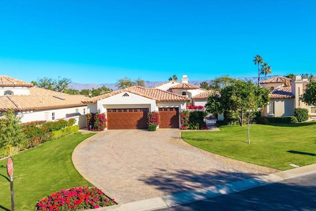 mediterranean / spanish-style home with a front lawn and a garage