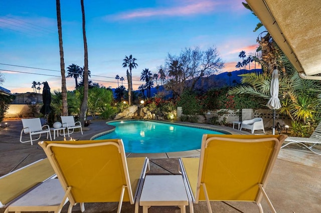 pool at dusk with a patio