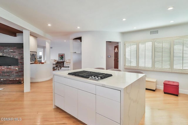 kitchen with light wood-type flooring, a center island, and white cabinetry