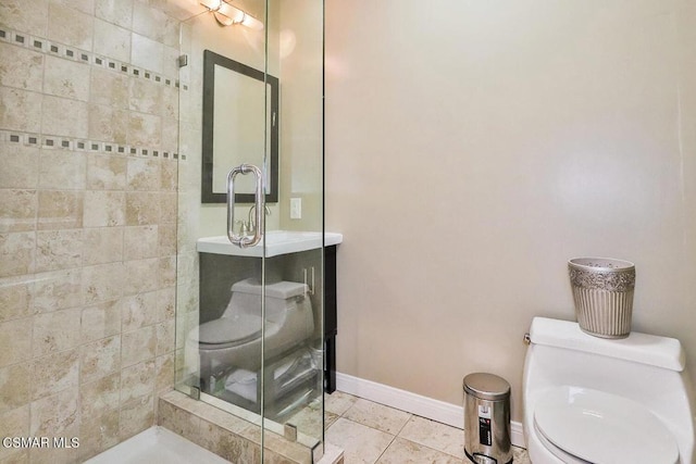 bathroom with tile patterned floors, toilet, and tiled shower