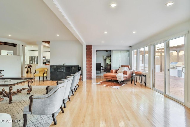 living room with decorative columns and light hardwood / wood-style flooring