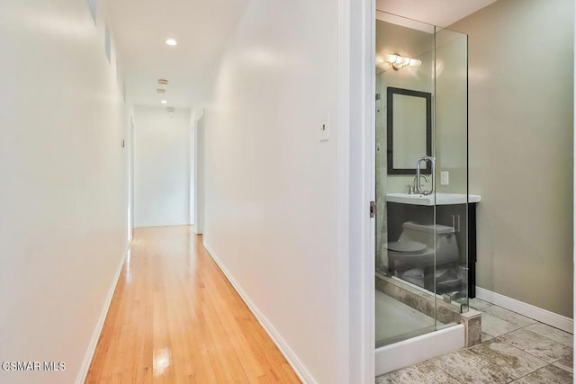 hallway featuring hardwood / wood-style floors and sink