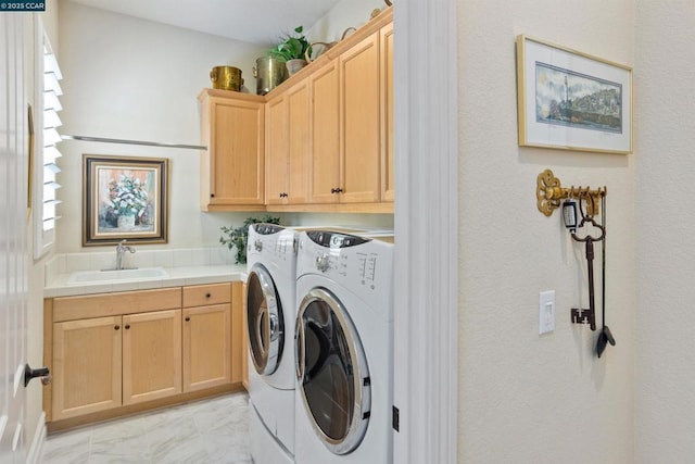 laundry area featuring cabinets, washing machine and clothes dryer, and sink