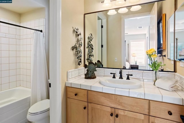 full bathroom featuring shower / bath combo with shower curtain, vanity, and toilet