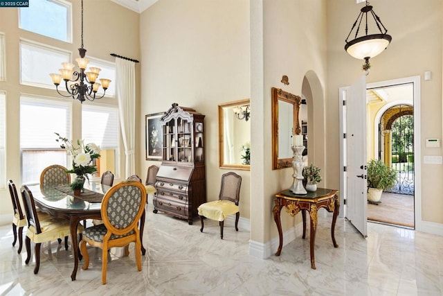 dining space featuring a high ceiling and an inviting chandelier