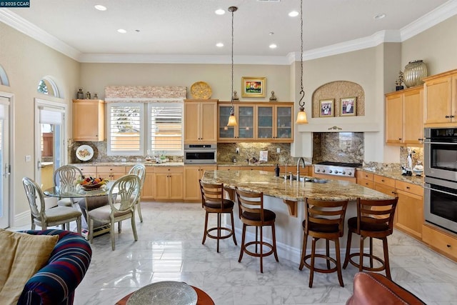 kitchen with tasteful backsplash, sink, an island with sink, and appliances with stainless steel finishes