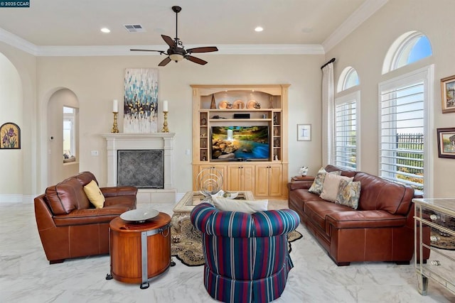 living room featuring ceiling fan, crown molding, and a high end fireplace