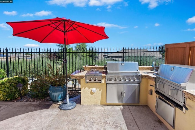 view of patio with area for grilling, sink, and grilling area