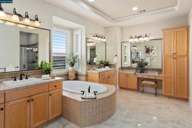 bathroom featuring vanity, a tray ceiling, and separate shower and tub