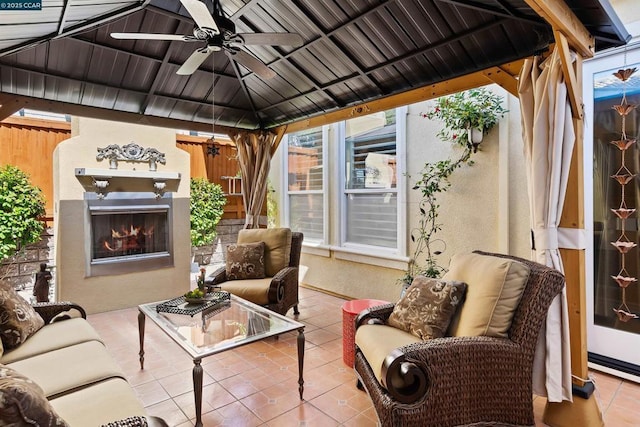 view of patio with a gazebo, ceiling fan, and an outdoor living space with a fireplace