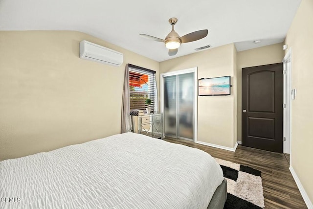 bedroom featuring dark hardwood / wood-style floors, an AC wall unit, and ceiling fan