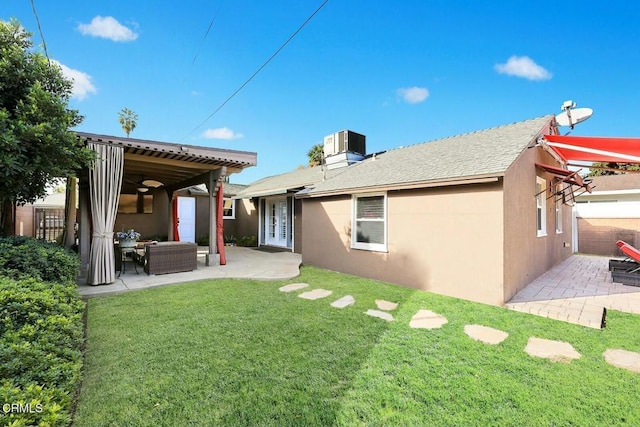 back of house with outdoor lounge area, a patio, central AC, and a lawn