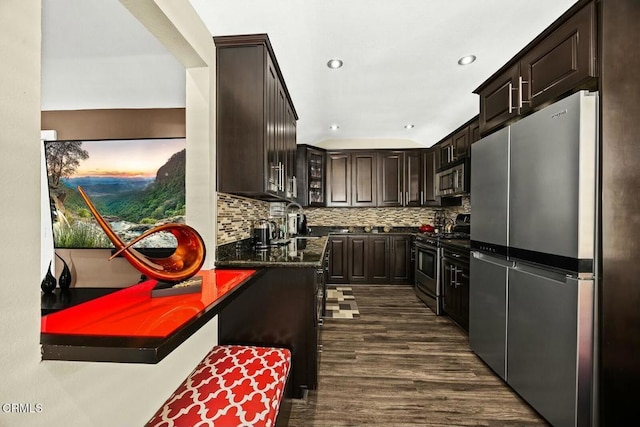 kitchen featuring decorative backsplash, dark brown cabinetry, stainless steel appliances, dark wood-type flooring, and sink